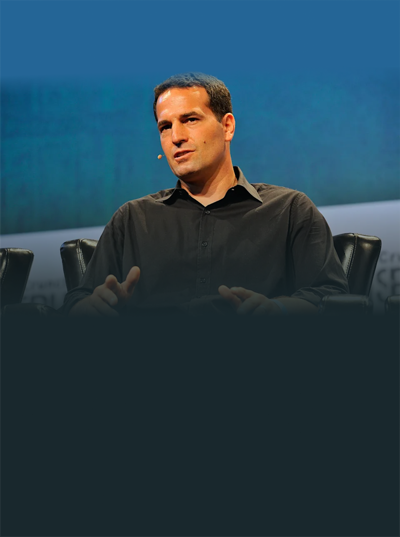 Keynote speaker sharing insights at an industry technology conference. Features a close-up profile of a fintech entrepreneur or industry executive presenting on a panel discussion stage.